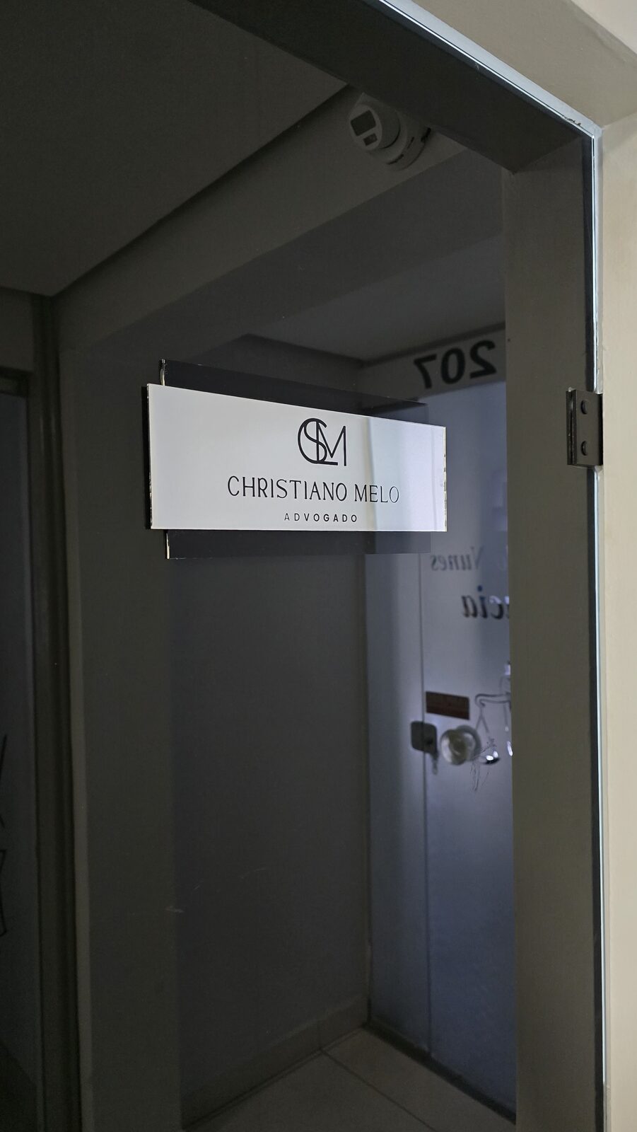 Entrada da sala do escritório, com placa de identificação
